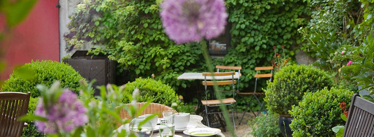 Feste feiern im grünen, blumigen Innenhof vom Café Kostbar